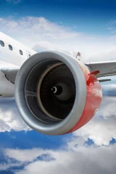 Airplane With Red Engine Flying Through Clouds Stock Photos