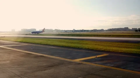 Airplane on runway exits frame through lensflare, 4K Stock Footage 56221812