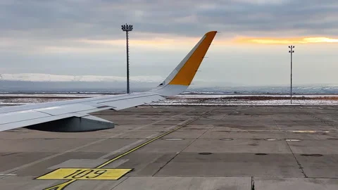 Airplane on the runway. View from window of plane. Yellow marks below. Sunlight Stock Footage 251323086