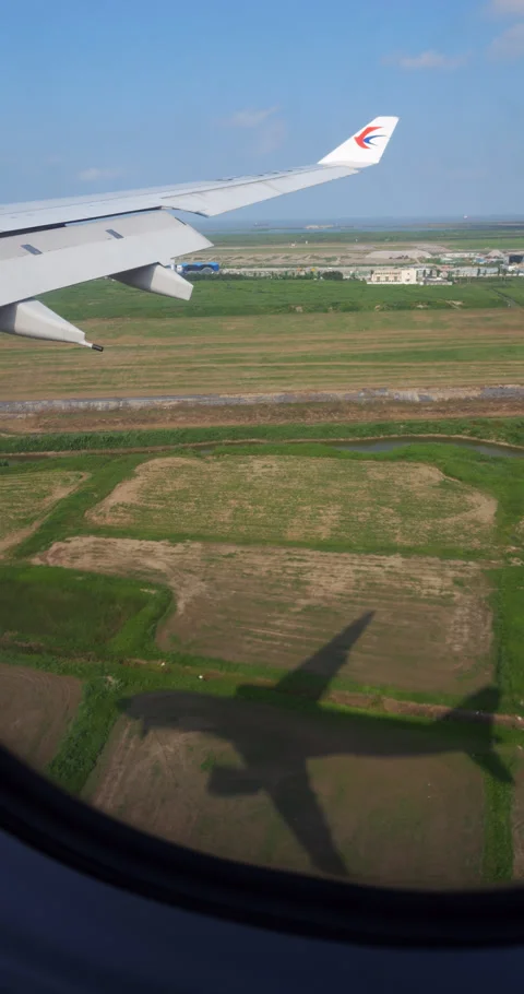 Airplane shadow reflecting on fields during landing, passenger perspective Stock Footage 297053561