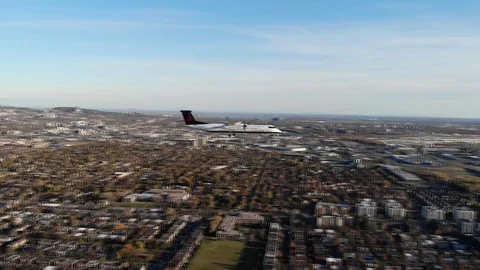 Airplane shot by a drone on the same altitude flying over city - propeller plane 動画素材 121823519