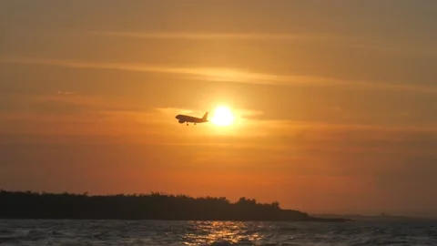  Airplane silhouette flying in front of the setting sun before landing Stock Footage 160976886