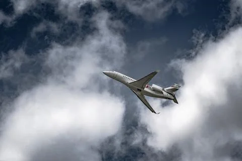 Airplane in the sky - cloudy day. Dramatic cloudy sky. Stock Photos