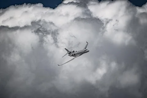 Airplane in the sky - cloudy day. Dramatic cloudy sky. Stock Photos