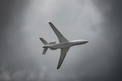 Airplane in the sky - cloudy day. Dramatic cloudy sky. Stock Photos