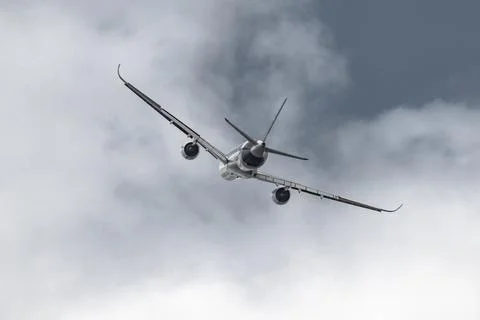 Airplane in the sky - cloudy day. Dramatic cloudy sky. Stock Photos
