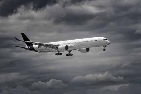 Airplane in the sky - cloudy day. Dramatic cloudy sky. Stock Photos