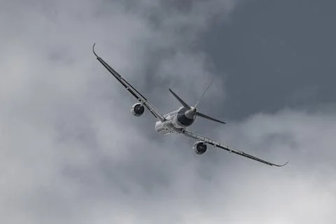 Airplane in the sky - cloudy day. Dramatic cloudy sky. Stock Photos