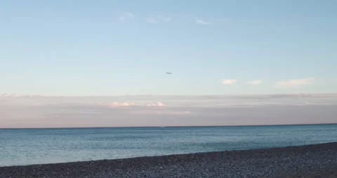 Airplane in the sky during a sunset flying over the sea. Stock Footage 166970704