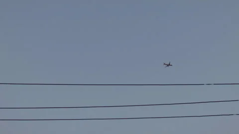Airplane in Sky thru Power Lines Stock Footage 185095401