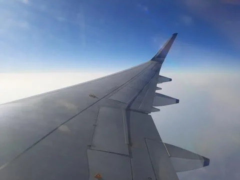 Airplane in the sky, window view of flight in the sky. wing of airplane. Stock Photos