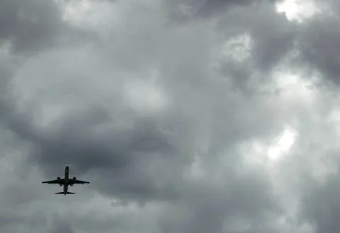 Airplane in storm clouds Stock Photos