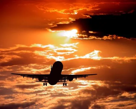 Airplane on sunset sky Stock Photos
