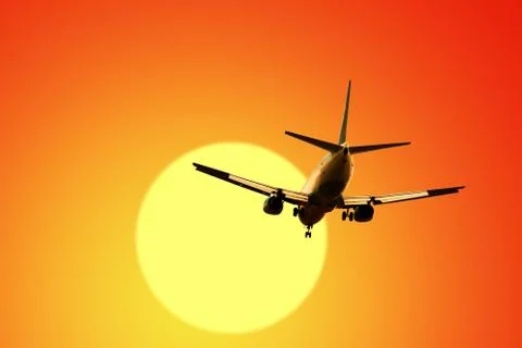 Airplane on sunset sky Stock Photos