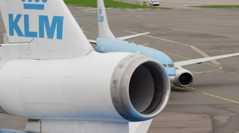 Airplane tail close up with engine and taxiing aircraft behind Vidéo 45999001