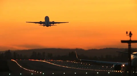 airplane taking off sunset