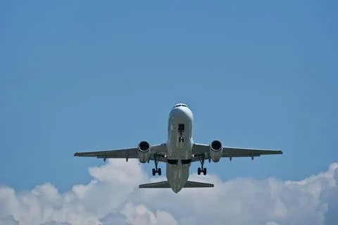 Airplane taking off against clouds Stock Photos