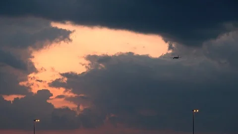 Airplane taking off and flying towards big clouds during sunset Stock-Footage 106947026