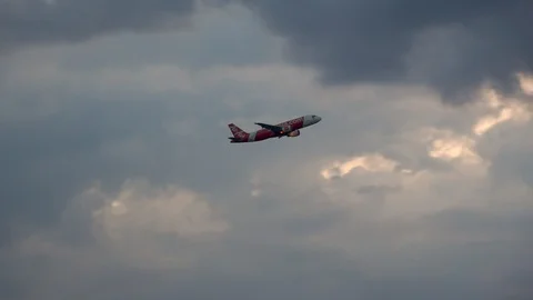 Airplane taking off and flying towards big clouds during sunset 스톡 동영상 106947122