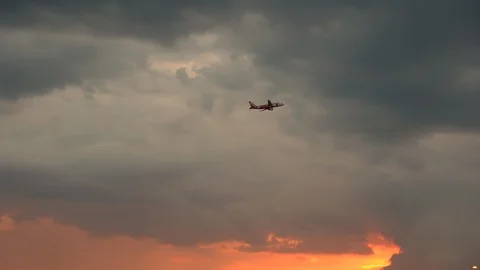 Airplane taking off and flying towards big clouds during sunset Stock-Footage 106947161