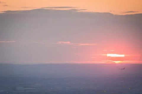 Airplane taking off during a glowing sunset Stock Photos