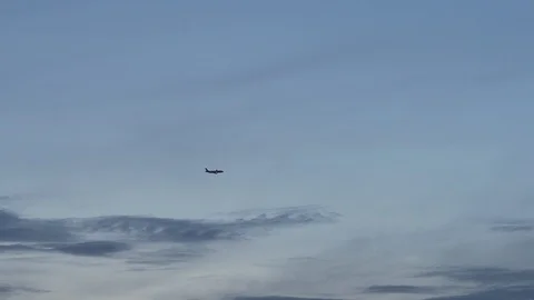 Airplane is taking off far away. Clear blue evening sky in the background Stock Footage 108884301