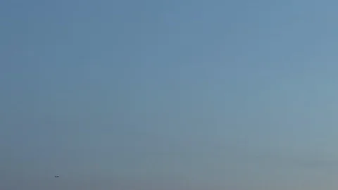 Airplane is taking off far away. Clear blue evening sky in the background Stock Footage 108884485