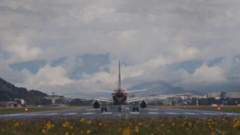Airplane taking off from runway with mountains in background Stock Footage 254880822