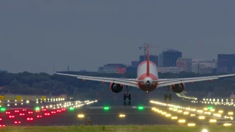 Airplane touching down on runway at dusk Stock Footage 283027591