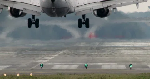 Airplane Touching Down on Tarmac with Large Puff of Smoke from Tires Stock Footage 254424964