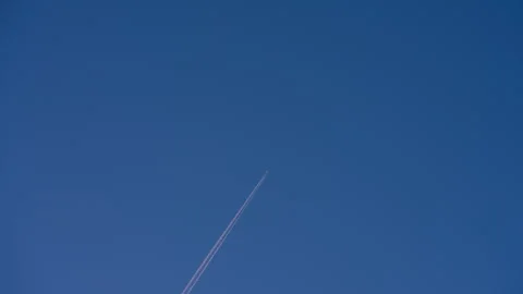 Airplane Trail Across Clear Blue Sky Stock Footage 338363471
