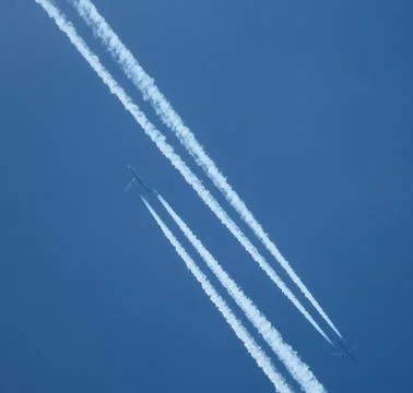 Airplane trail in the blue sky, parallel contrails Stock Photos