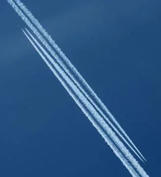 Airplane trail in the blue sky, parallel contrails Stock Photos