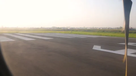An airplane turning in a runway with a view of plain land and a windsock Stock Footage 281219429