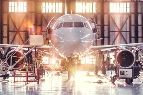 Airplane under repair in the aerospace hangar in the background of the gate a Stock Photos