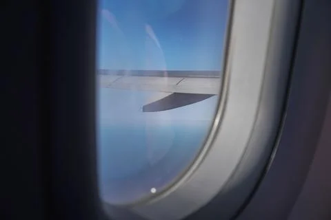 Airplane window with a blurred wing Stock Photos