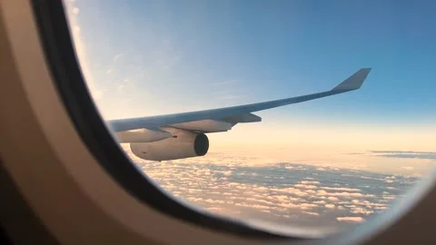Airplane Window Flight Over Clouds at Sunset with Wing View Stock Footage 333693456