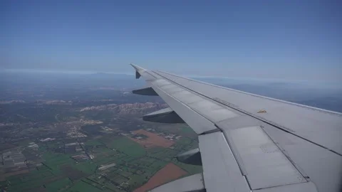 Airplane window flight view above ground, sky no clouds. Infrastructure below 库存影片 219743112