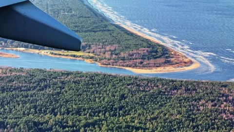 Airplane Window Shot Over Baltic Sea Coastline and Forest Peninsula Near Riga Stock Footage 336813027