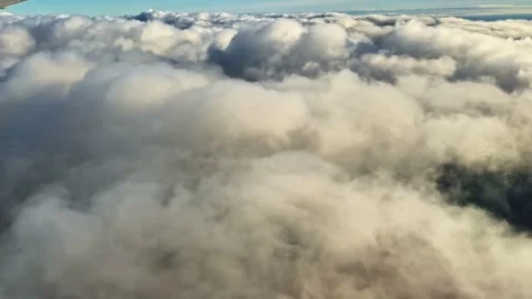 Airplane Window Shot Over Cloud Layer and Landscape Below in Riga Latvia Stock Footage 336813145
