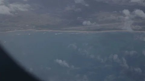 Airplane window showing intense blue sea with clouds over Video stock 127874780