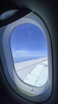 Airplane window with sky outside Stock Photos
