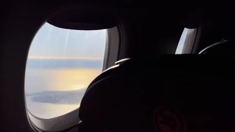 Airplane Window Sunset View Over Water With Dark Cabin Seat Silhouette Stock Footage 328834988