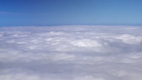 Airplane window view above clouds, blue sky horizon - Cloudtops and Cloud Bank Stock Footage 339474547