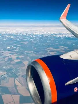 Airplane Window View Above Clouds With Wing And Engine Over Agricultural Fiel Stock Photos