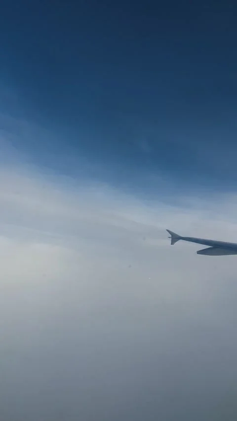 Airplane Window View Breaking Through Clouds to Clear Sky Stock Footage 336494814