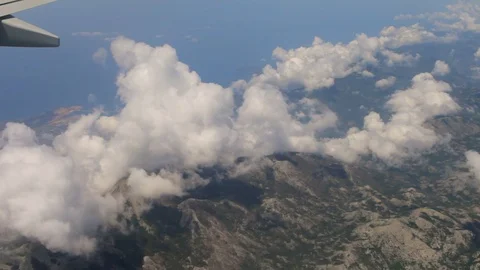 From the airplane window view of the clouds and mountains 動画素材 91571437
