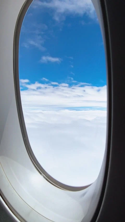 Airplane window view, clouds and blue sky background, travel concept. Stock Footage 345524628
