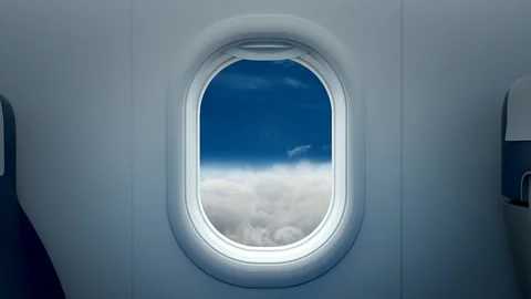 Airplane window view of clouds from inside the cabin Stockbeeldmateriaal 335825553