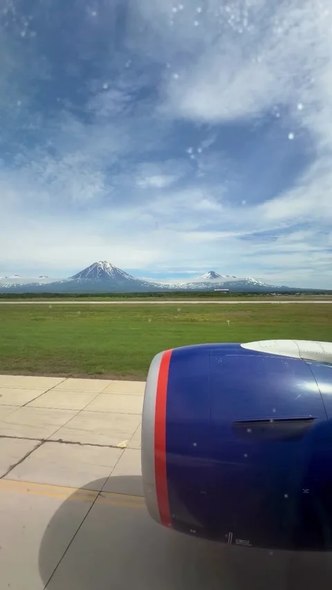 Airplane Window View of Engine and Snow-Capped Volcanoes Video stock 341133011